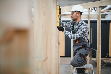 Worker carpenter assembling a modular house