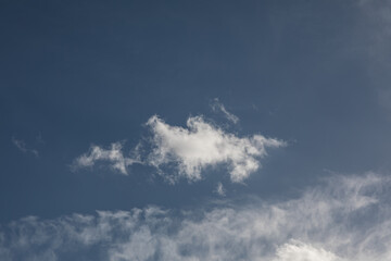 Deep blue sky with single bright cloud and high contrast atmosphere  
