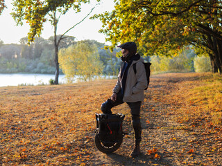 young man on electric unicycle in autumn park © pavelkant