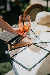 A person is holding a glass of wine with a straw in it