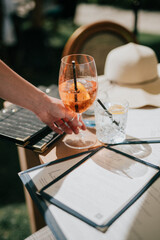 A person is holding a glass of wine with a straw in it