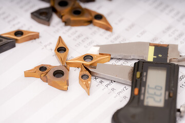 Precision measurement of cutting tools in a manufacturing workspace at noon