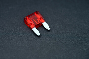 Red automotive fuse on a dark background for electrical component identification