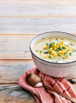 Bowl of corn chowder with napkin and spoon