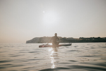 Fototapeta premium A man is sitting on a surfboard in the ocean