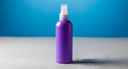 Purple spray bottle on textured fabric with blue background, contemporary cosmetic or cleaning product design, closeup studio shot of glossy plastic container, hygiene perfume household care accessory
