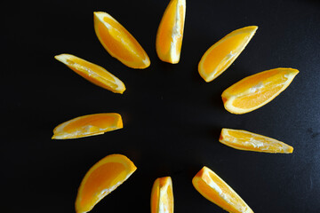 Fototapeta premium Orange slices forming a circle on a black background
