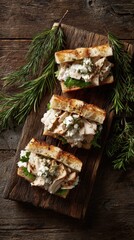 Fototapeta premium Three herb-topped grilled chicken sandwiches on a wooden board with greenery