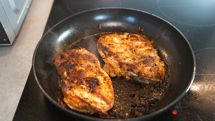 Seasoned chicken fillet sizzling in a frying pan, cooked to a golden brown with herbs and spices. Perfect for healthy eating content, quick dinner ideas, or home cooking blogs. Close-up shot with stea