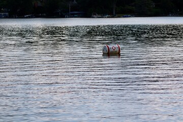 Drifting Barrel on a Tranquil Lake With Rippling Water and Surrounding Greenery Reflecting the Calm Atmosphere at Sunset
