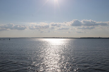 Breathtaking View of Shimmering Water Reflecting Sunlight With Distant Clouds Over the Horizon During a Tranquil Afternoon