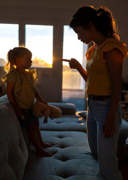 Mother reprimands daughter during sunset at home