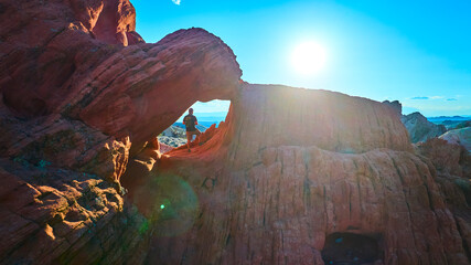 Red Rock Arch Formation with Hiker and Sun at Whitney Pocket Nevada