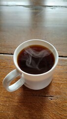 Obraz premium A Steaming Mug of Coffee on a Wooden Table