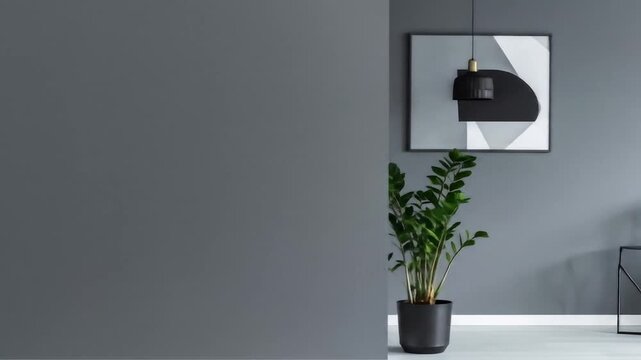 Modern Gray Interior Featuring an Abstract Art Piece and a Green Plant in a Black Pot Against a Monochromatic Wall With Empty Space