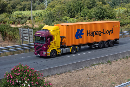 Scania truck carrying hapag-lloyd container on highway