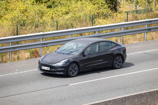 Black tesla model 3 driving on the highway
