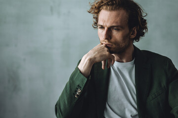 Frontal portrait of young self confident handsome young man in a t-shirt, modern suit or shirt in stylish loft interior, grey walls. Casual closing, fit, slim. Idea for groom male wedding photoshoot