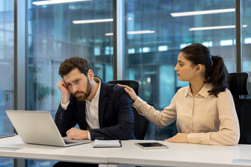 Businesswoman supporting a colleague experiencing stress in a professional office setting