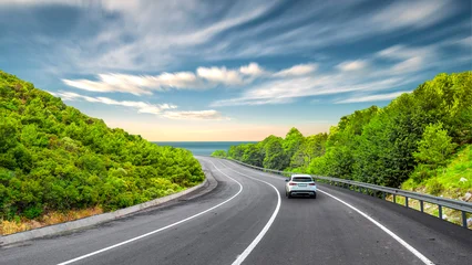 Selbstklebende Fototapeten Mediterranes Europa car driving on the road of europe. road landscape in summer. it's nice to drive on the beach side highway. Highway view on the coast on the way to summer vacation. Europe trip on beautiful travel road  © ZEHRA