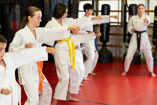 Group of children and teenagers practicing karate technique in gym