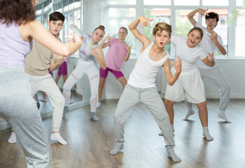 Group of boys and girls rehearsing hip hop dance in studio
