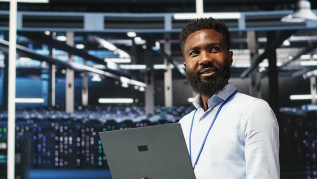 Portrait of cheerful data center engineer analyzing gear issues using node tree tools. Upbeat African american server hub specialist using AI visualization insights to optimize system health, camera B