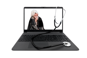Laptop and medical stethoscope isolated on transparent background. On the laptop screen - a girl with cold symptoms blows her nose into a paper handkerchief	