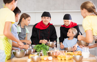 Two chefs teach children how to cook food - they beat eggs with a whisk
