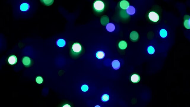 real life multicoloured bokeh with a dark black background as the camera passes over defocussed multi-coloured fairy lights softly twinkling in various sequence patterns 4K