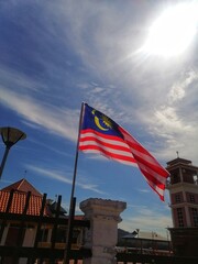 Malaysian flag on a building, blue background 