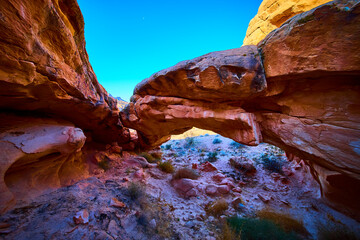 Sandstone Arch Formation Framed by Desert Landscape and Blue Sky
