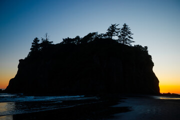 Sunset at Ruby Beach, Olympic National Park, Washington State. Colorful sky reflecting on wet sand with sea stacks and gentle ocean waves.