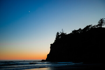 Sunset at Ruby Beach, Olympic National Park, Washington State. Colorful sky reflecting on wet sand with sea stacks and gentle ocean waves.
