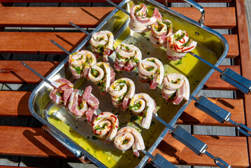 Marinated pork belly skewers with herbs prepared for grilling.