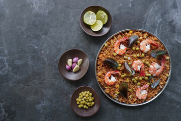 Paella is a Spanish dish made from rice, seafood, shrimp, clams, lemon, peas with saffron seasoning.