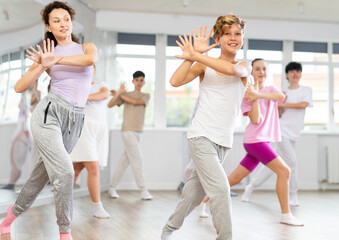 Naklejka premium Group of teenagers learn to dance hip-hop and other modern dances in a spacious dance studio