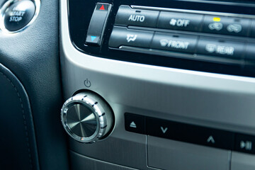 Car center console, air conditioning switch knob, entertainment and climate controls in a luxury car. Close up. High quality photo