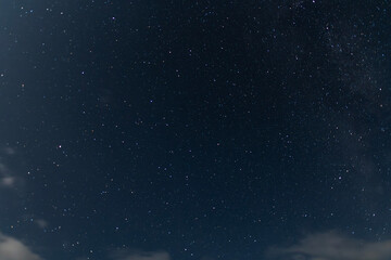 Beautiful starry sky with clouds in the night. Night sky background.