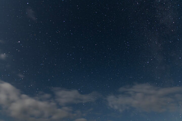 Beautiful starry sky with clouds in the night. Night sky background.