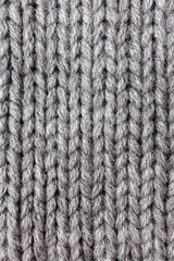 Gray knitted wool fabric close up – handmade textile cloth, thick yarn knitwear pattern, cozy woolen clothing material for winter apparel