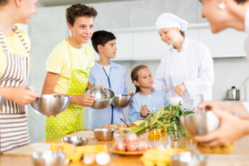 Teenage children are interested in learning in culinary courses under the supervision of two adult chefs