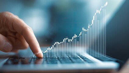 A hand hovers over a laptop keyboard, overlaid with a rising stock chart