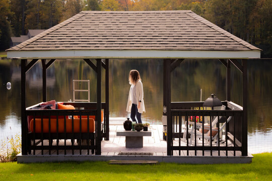 woman at a lake in fall under a gazebo