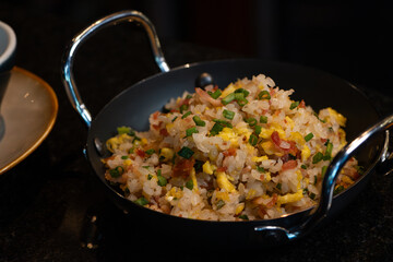 Asian Fried Rice with eggs and vegetables  in black iron pan