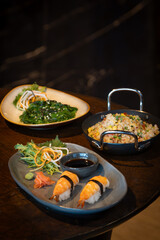 Fresh Off nigiri sushi served on a  plate with soy sauce and vegetables