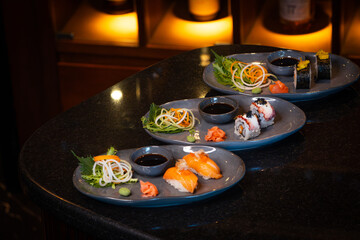 Fresh Off nigiri sushi served on a  plate with soy sauce and vegetables