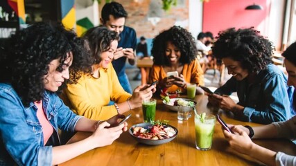 Diverse group of friends enjoying meal, scrolling on phones and socializing in urban cafe, - Powered by Adobe