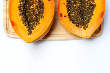 Fresh ripe papaya fruit cut in half on a wooden board with bright orange flesh and black seeds, symbolizing tropical freshness, organic nutrition, and healthy lifestyle food.
