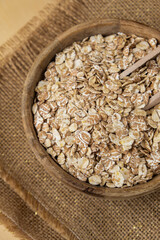 Raw oatmeal porridge in neutral beige background copy space. Whole spelt grain species. High protein fiber-rich vegan plant based food ingredient. Gluten free superfood healthy nutritional dietary